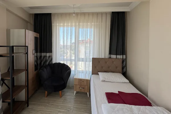 Gardırop, komodin ve oturma koltuğuyla ferah öğrenci odası